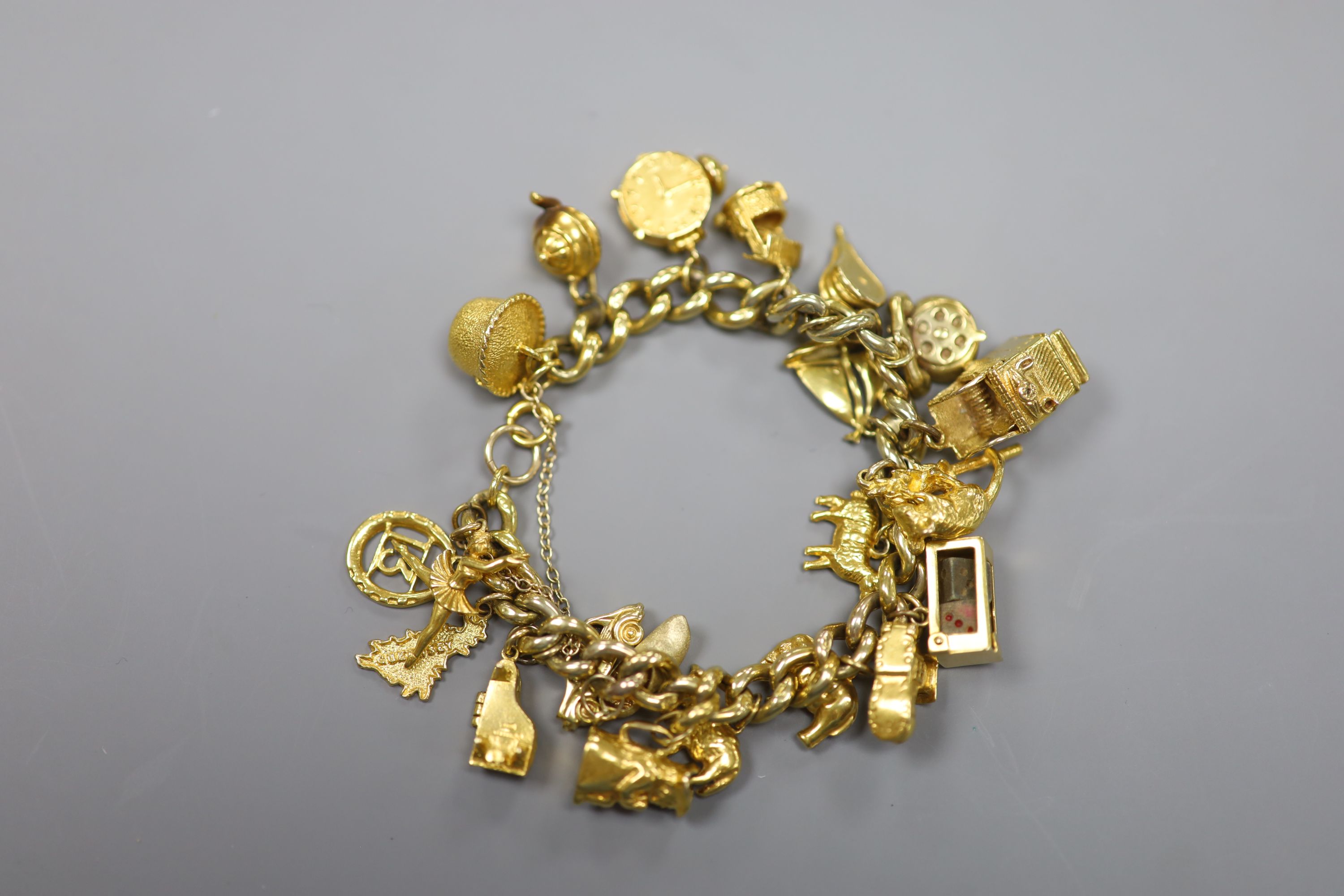 A 9ct curb link charm bracelet hung with twenty one assorted mainly 9ct gold charms